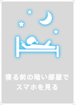 寝る前の暗い部屋でスマホを見る